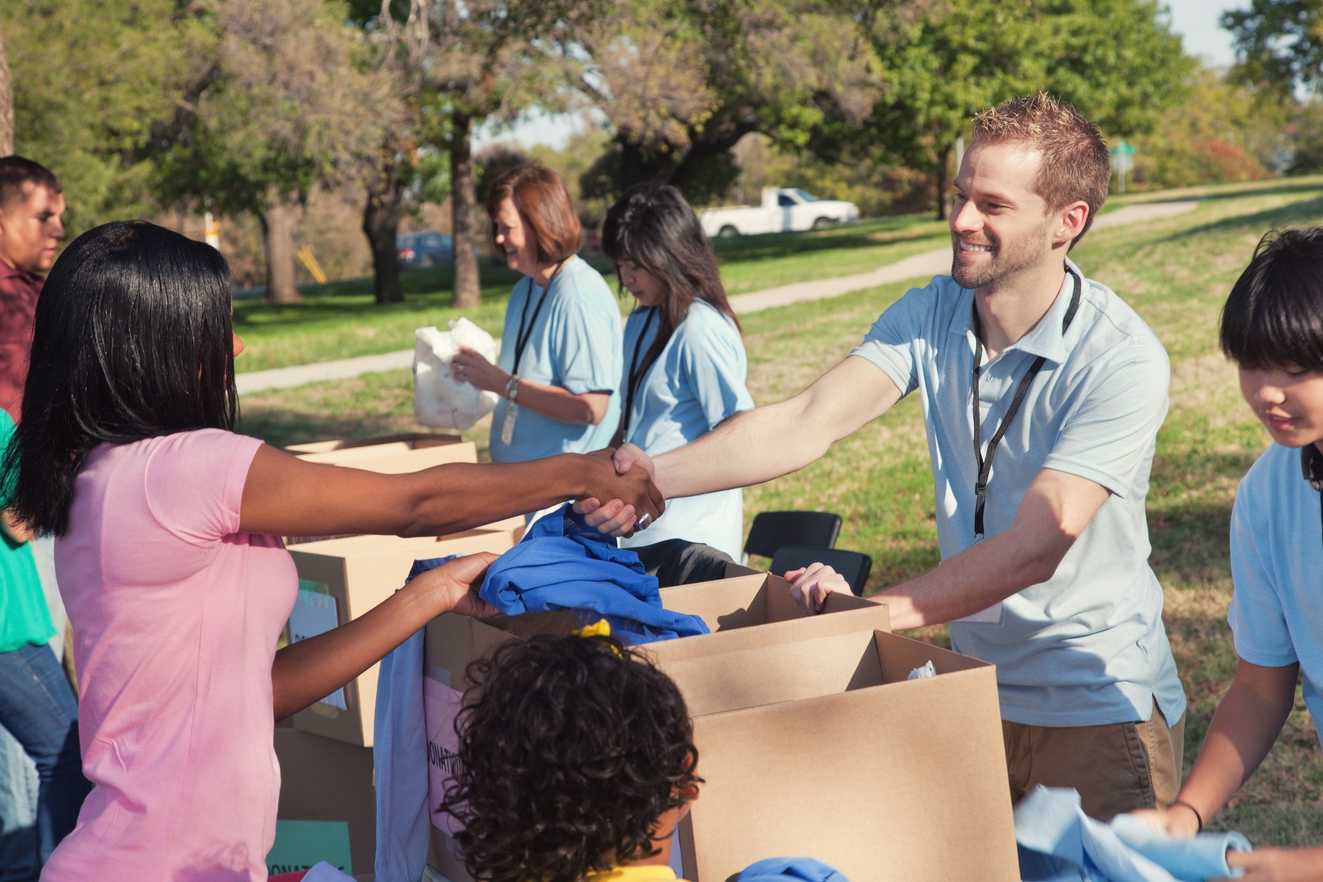 Male volunteer greets woman during clothing drive