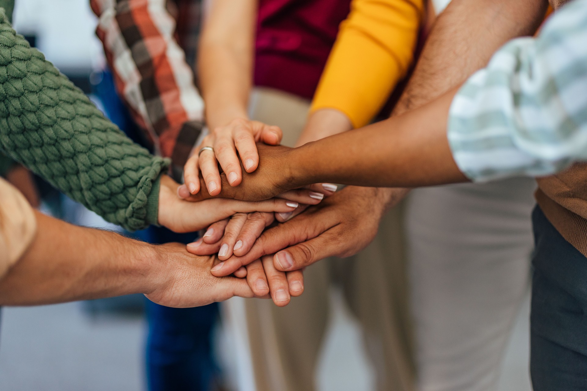 Close up of people's hands, holding in the middle, working as a team.